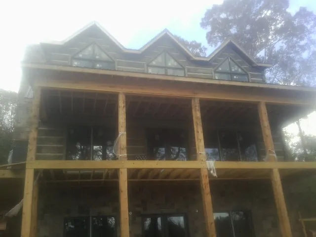 Dormers and porch framing on a large log home under construction — Roof Coating work by our crew in Mobile