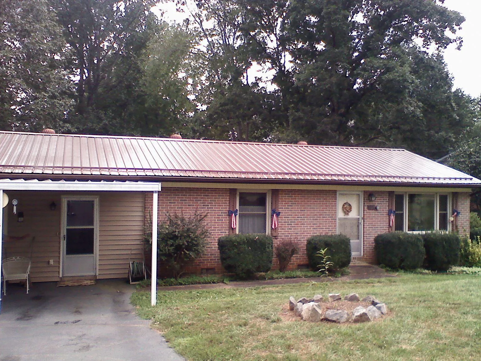 Bronze metal roof and carport on a brick ranch home — Roof Repair work by our crew in Mobile