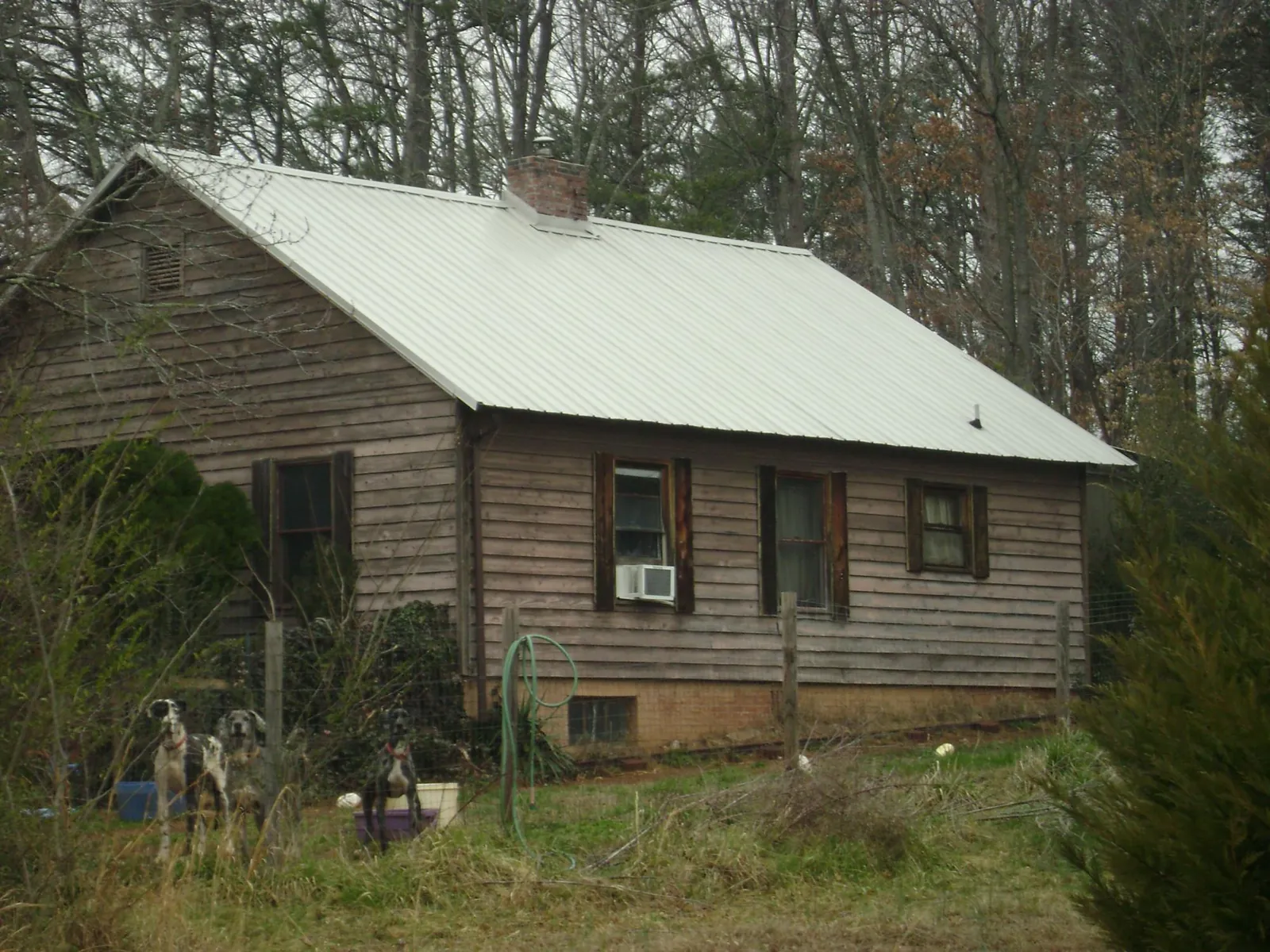 White metal roof on an old wood sided farmhouse, from a Metal Roof Installation job in Mobile